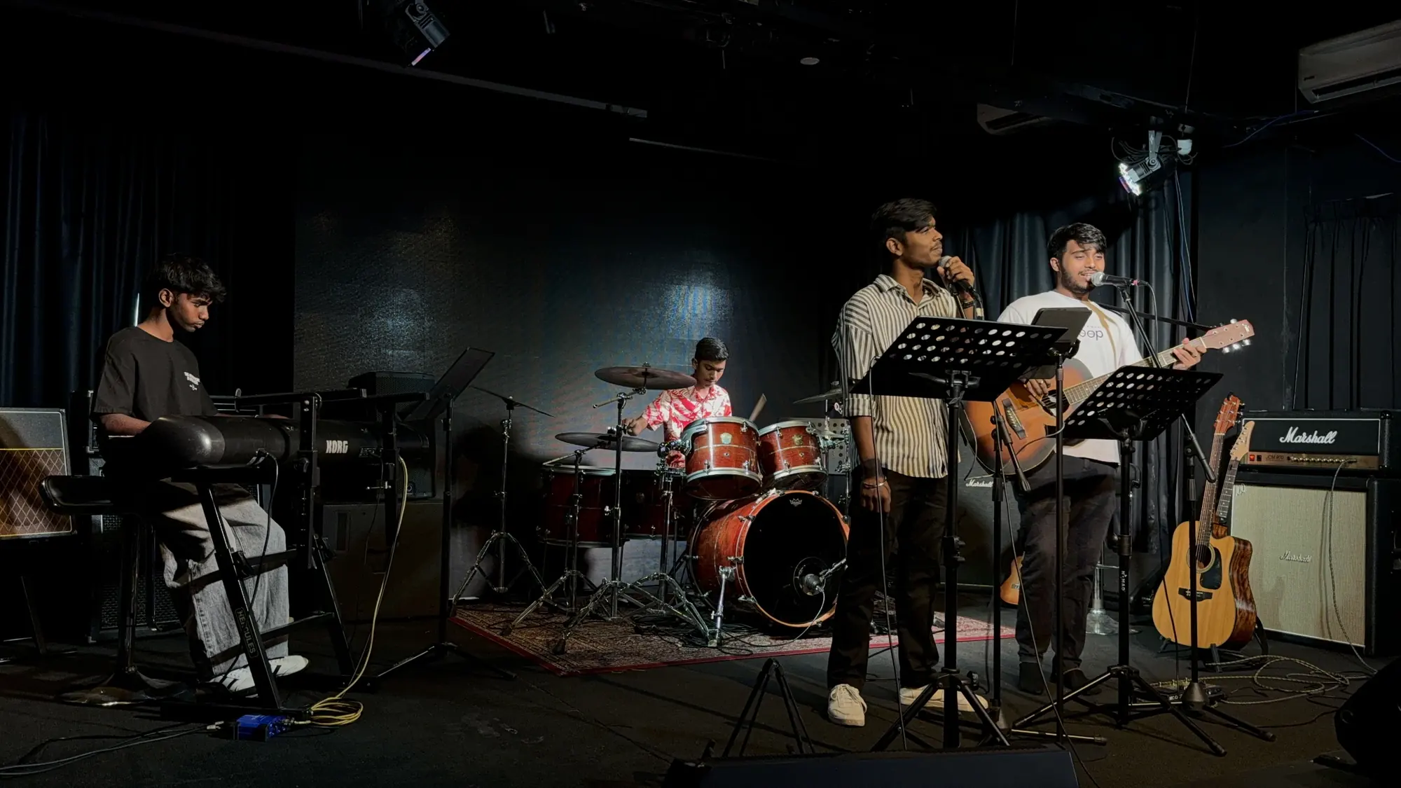 JD. Music Academy band performing on keyboard, drums, vocals and guitar