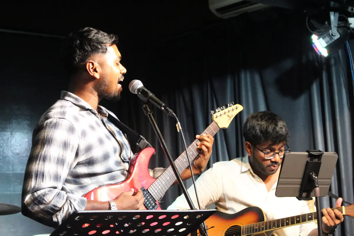 Guitarists singing on stage at Open Day 2025